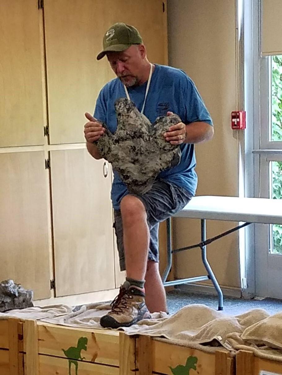 Dinosaur Discoveries T-Rexplorers showing a fossil at a library presentation.